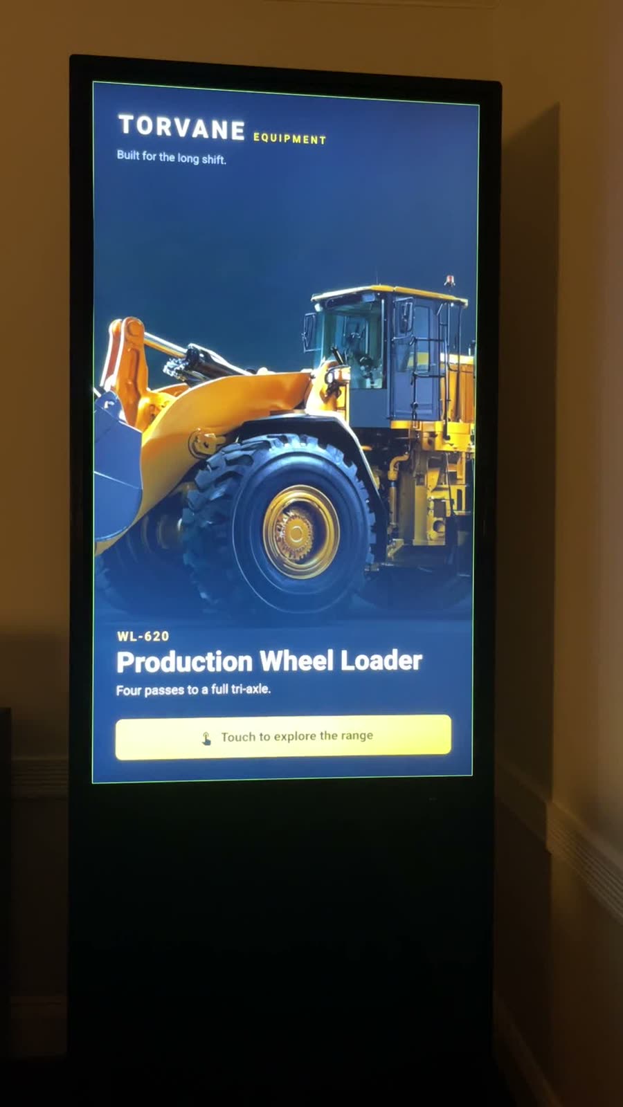 A 55-inch portrait kiosk running a product explorer attract screen